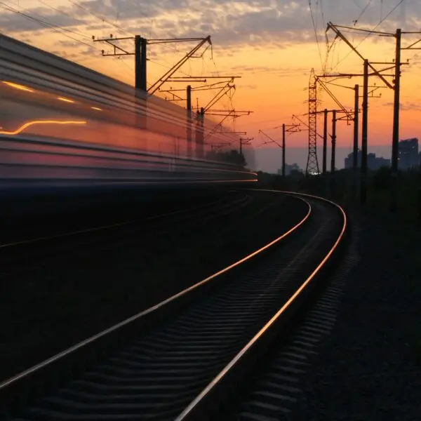 An empty railway track under a cloudy sunset.