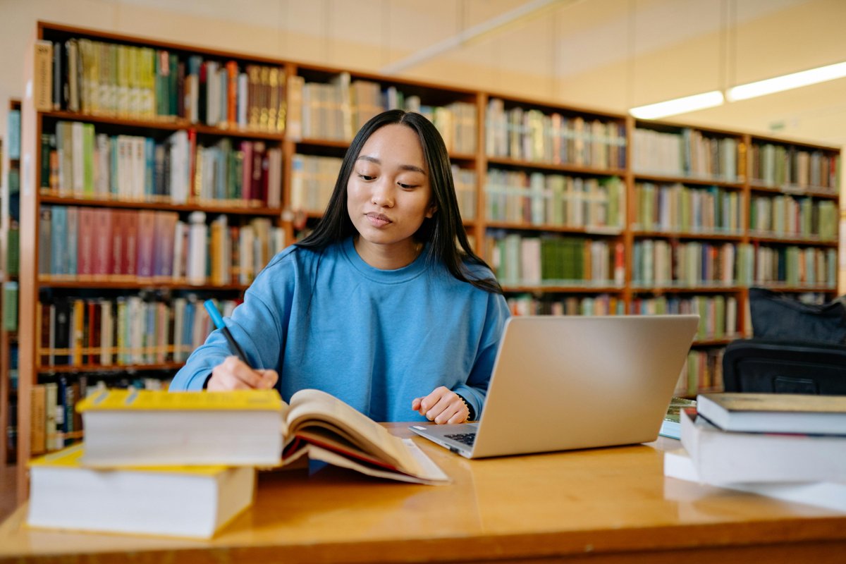 A young female student studies for her exams in a university library.